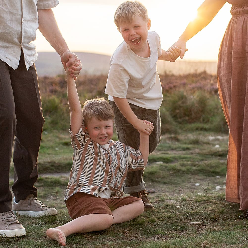 A family of four play joyfully at sunset on Yorkshire moors.