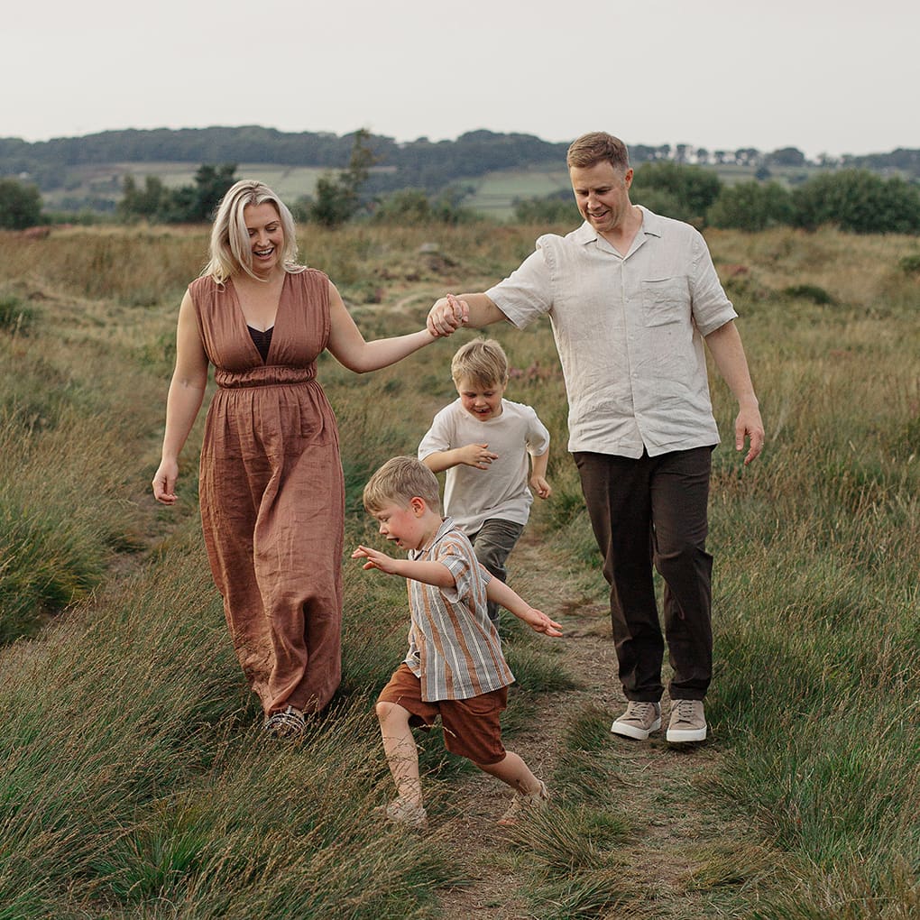 Two boys run around their parents during a family photography session.
